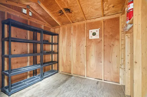 a view of a small room with wooden floor and windows