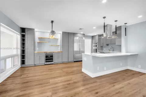 a kitchen with kitchen island a stove a sink and a wooden floor