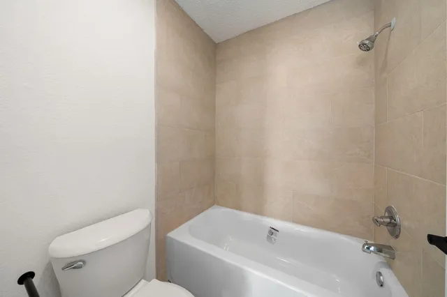 a white bath tub sitting next to a white toilet and sink