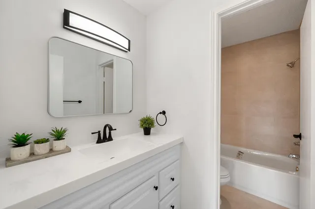 a bathroom with a sink a mirror and vanity