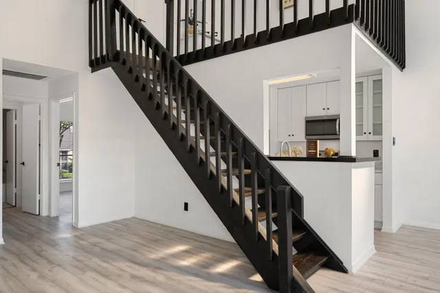 a view of a hallway with wooden floor and staircase