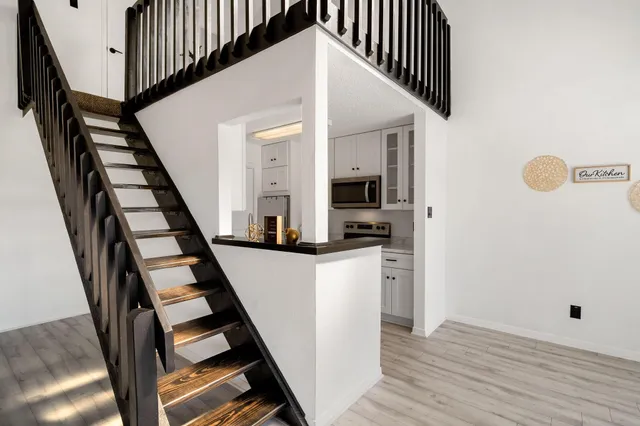 a view of a kitchen with wooden floor and electronic appliances
