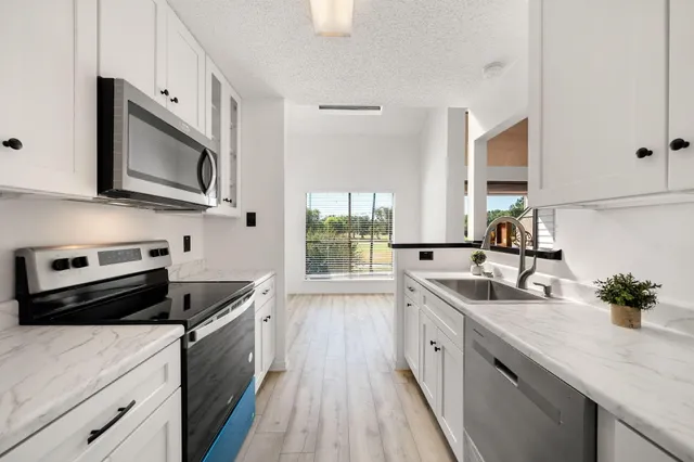 a kitchen with stainless steel appliances a sink stove and microwave