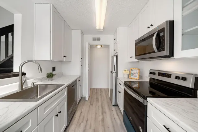 a kitchen with stainless steel appliances granite countertop a sink stove and refrigerator