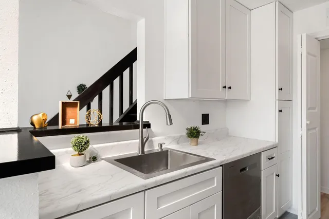 a kitchen with a sink and white cabinets