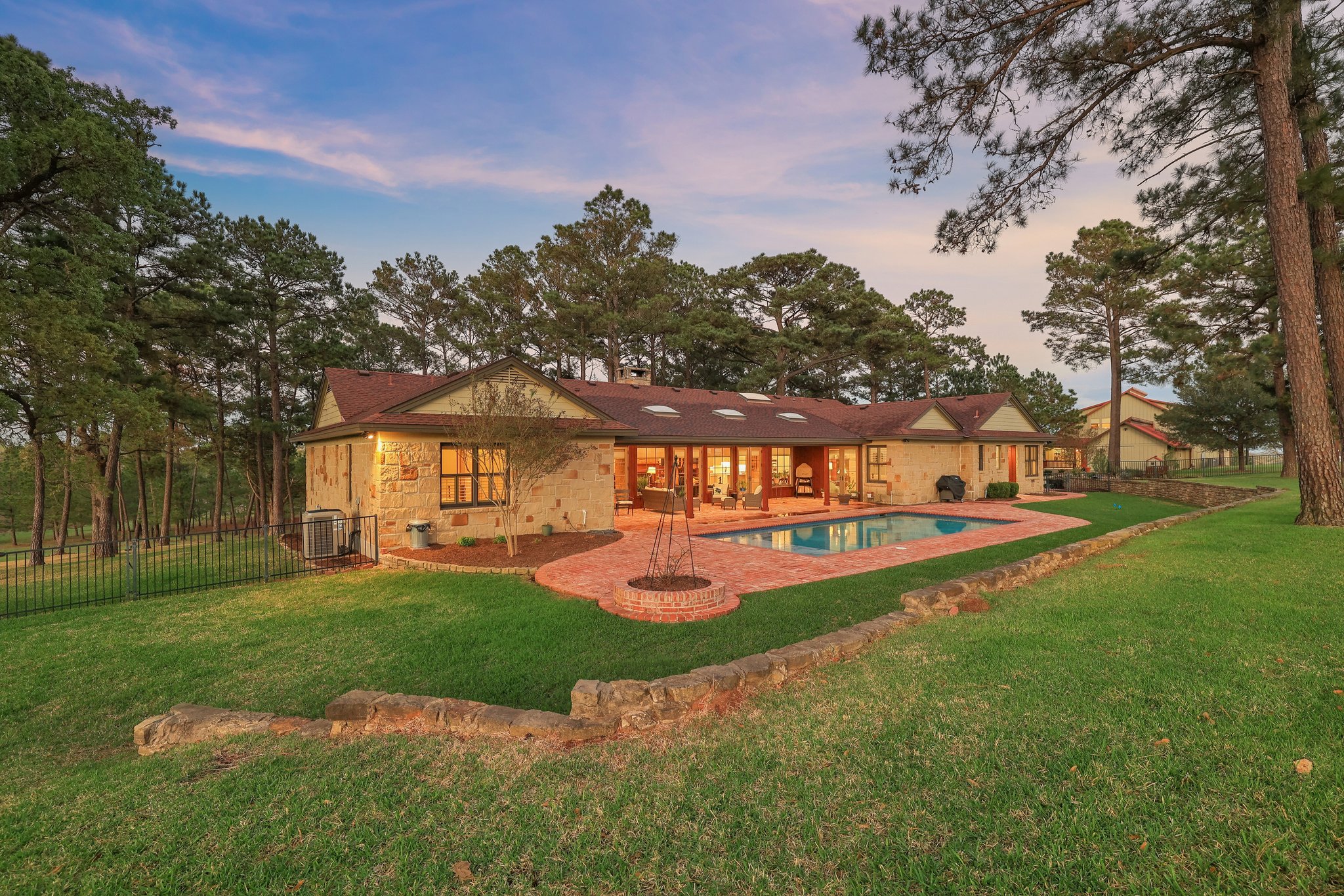 546 McAllister Road Bastrop, TX 78602 - Photo 31 of 40 Back of property at dusk featuring a patio and stone siding