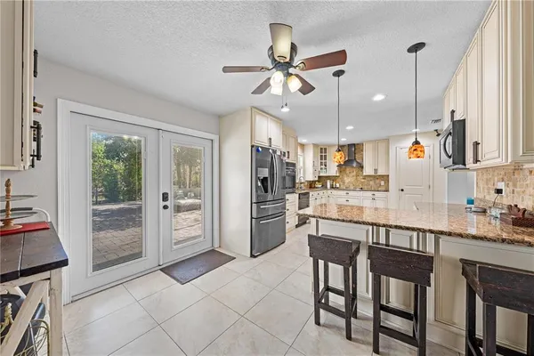 a open kitchen with stainless steel appliances kitchen island granite countertop a refrigerator and a sink