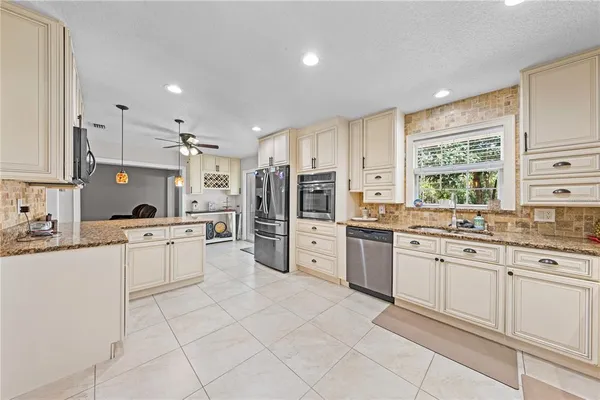 a kitchen with stainless steel appliances granite countertop a refrigerator and a stove top oven