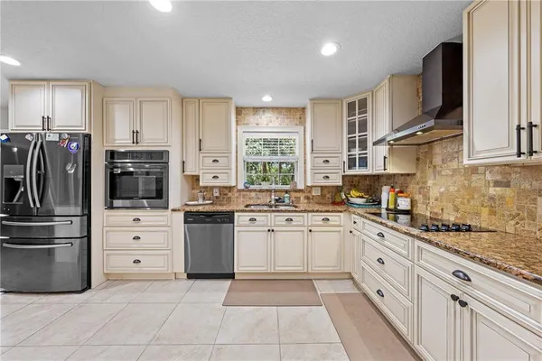 a kitchen with white cabinets and refrigerator