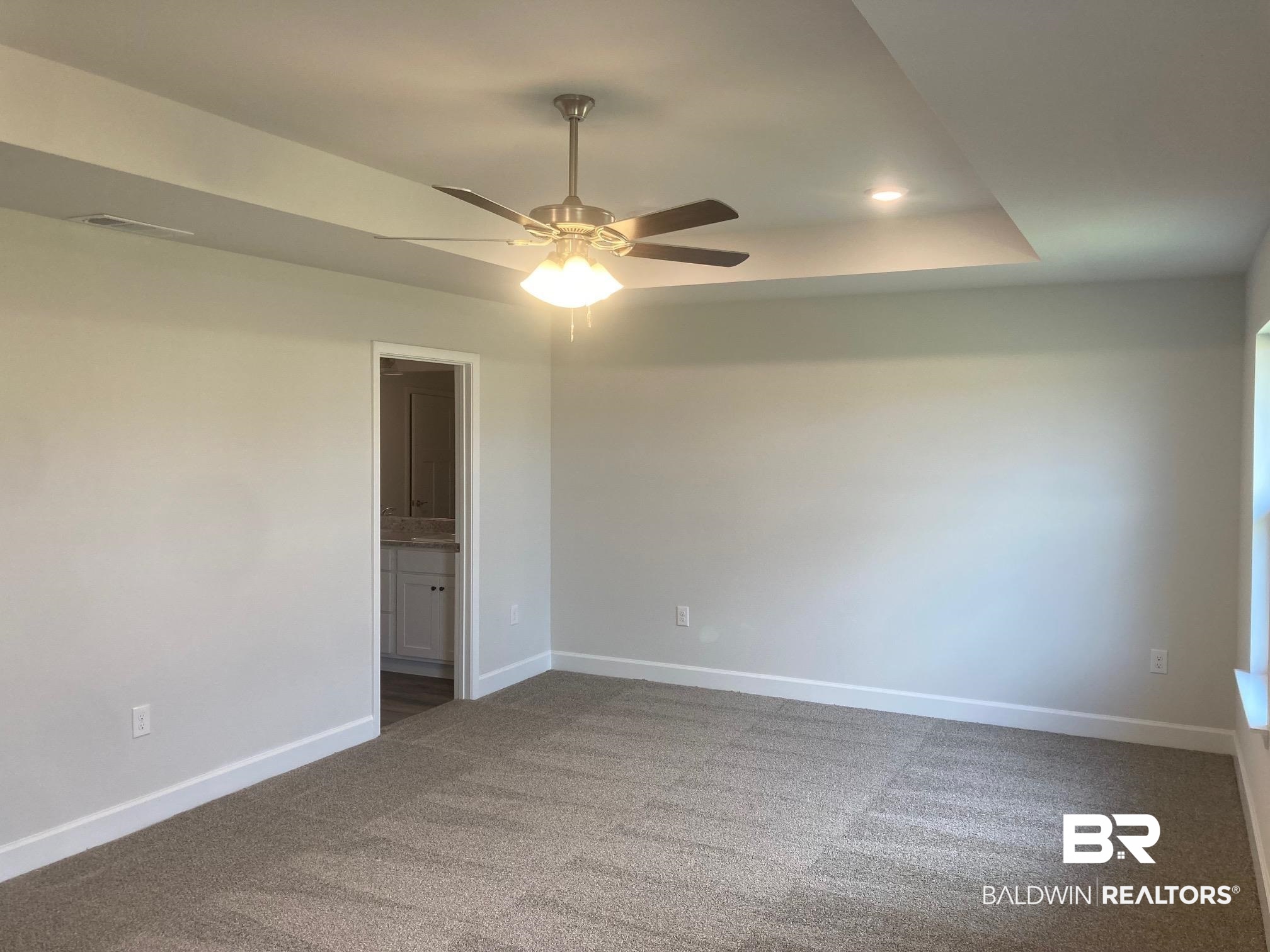 629 Revere Street Foley, AL 36535 - Photo 18 of 30 Carpeted empty room with ceiling fan and a raised ceiling
