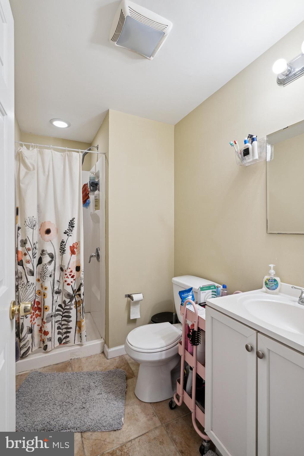 1611 North 17th Street, Unit A Philadelphia, PA 19121 - Photo 12 of 19 a bathroom with a sink a toilet and shower curtain