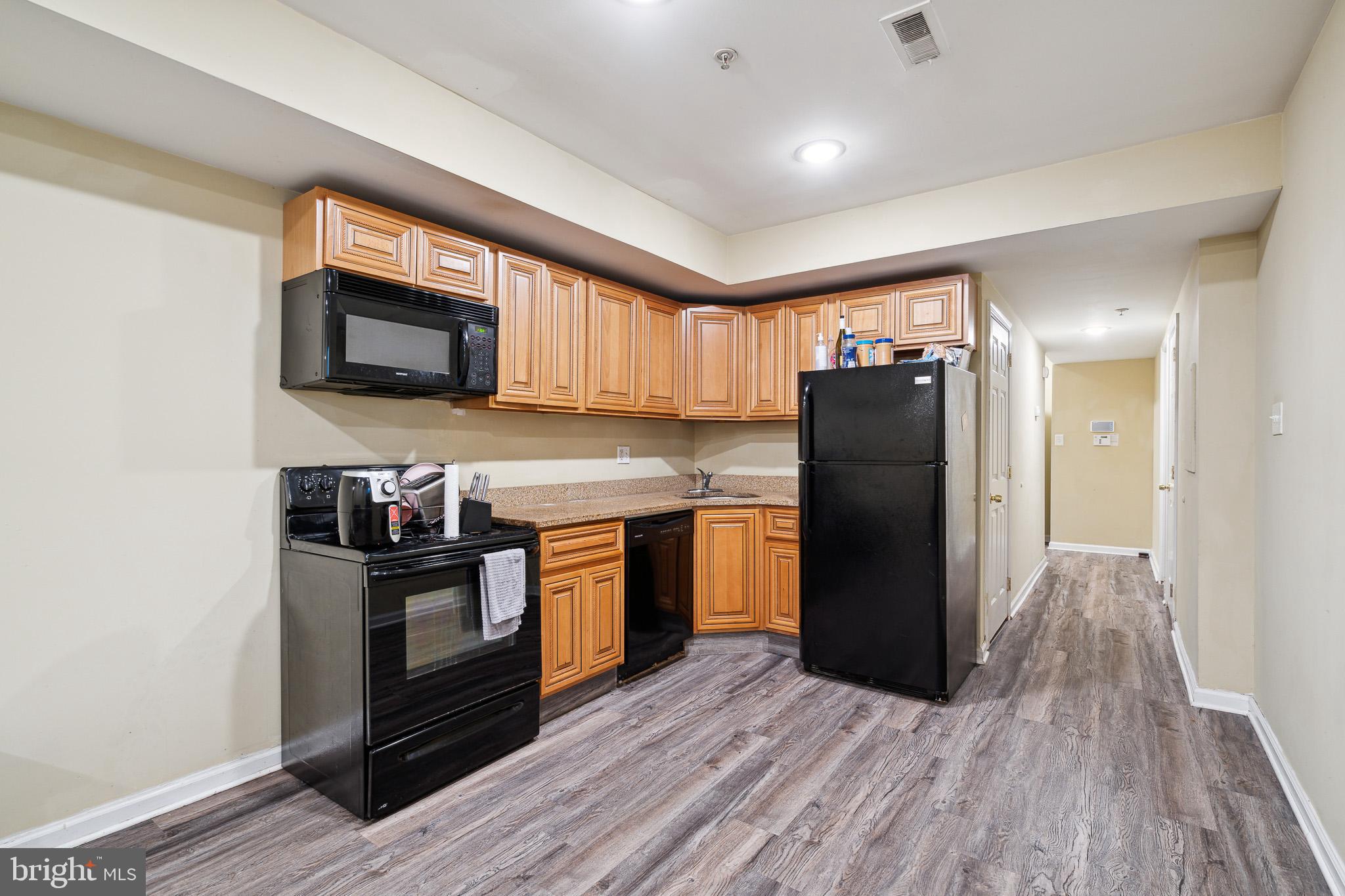1611 North 17th Street, Unit A Philadelphia, PA 19121 - Photo 2 of 19 a kitchen with stainless steel appliances granite countertop a refrigerator microwave and sink