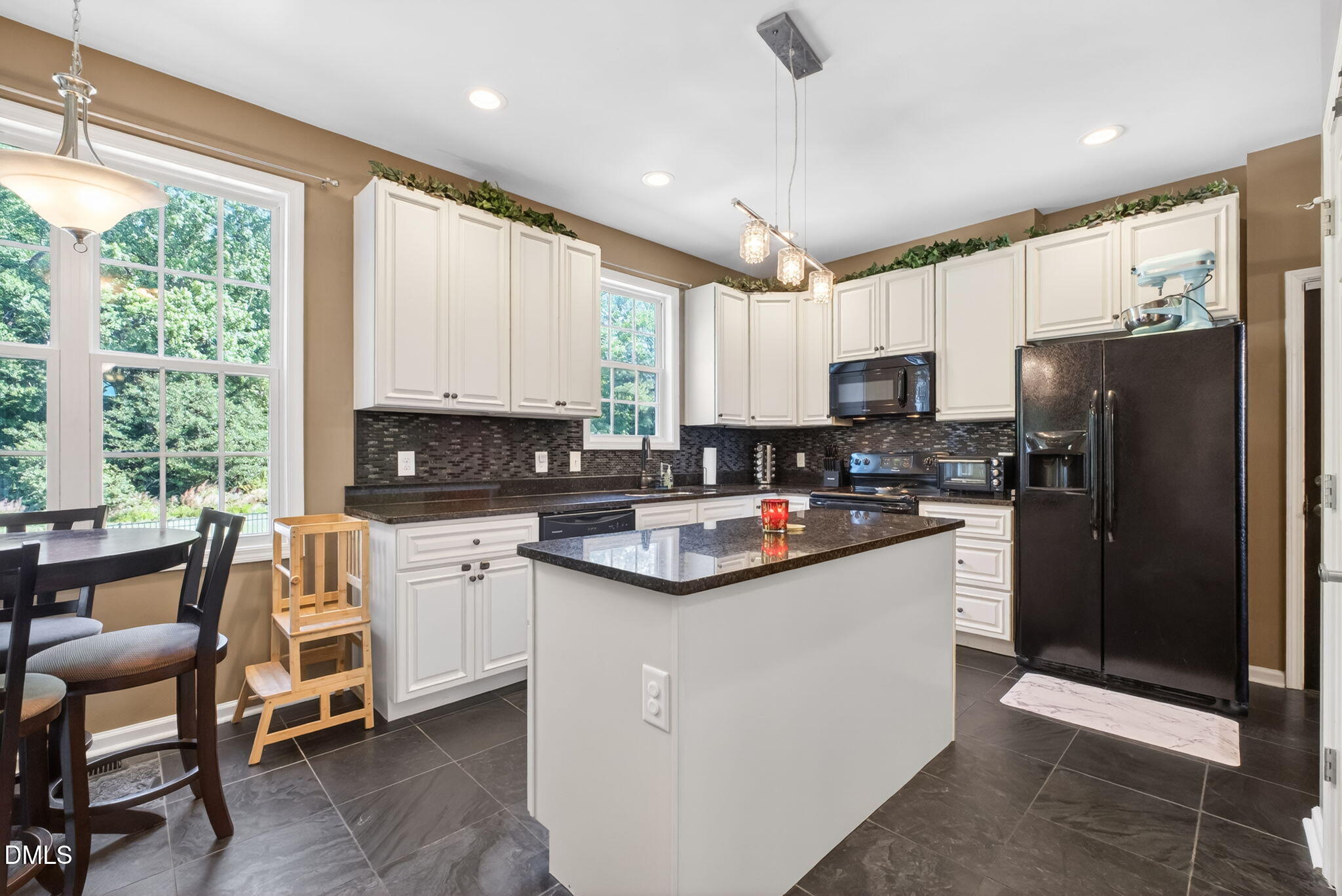923 White Memorial Church Road Willow Spring, NC 27592 - Photo 19 of 46 a kitchen with stainless steel appliances granite countertop a refrigerator a stove a sink a stove and white cabinets with wooden floor