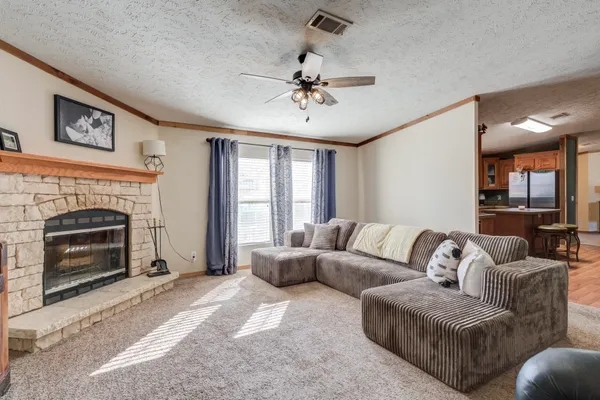 a living room with furniture a flat screen tv and a window