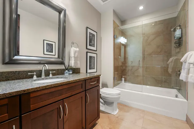 a bathroom with a bathtub shower sink vanity and toilet