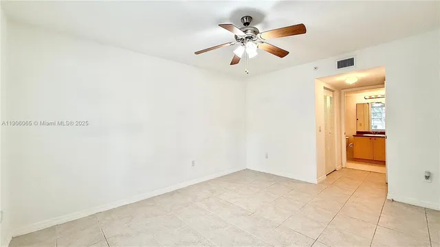 an empty room with closet and a chandelier fan