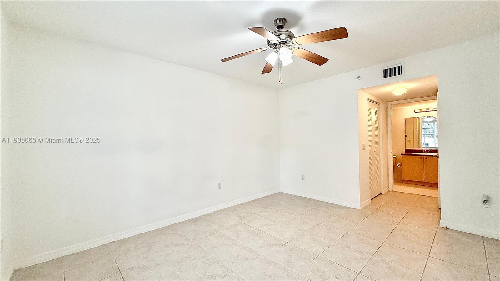 4211 San Marino Boulevard, Unit 205 West Palm Beach, FL 33409 - Photo 11 of 22 an empty room with closet and a chandelier fan