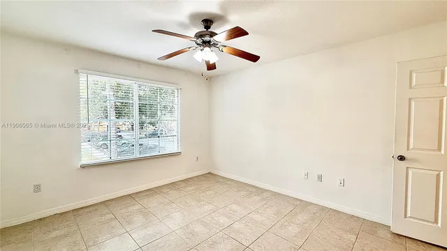 a view of a big room with windows and chandelier fan