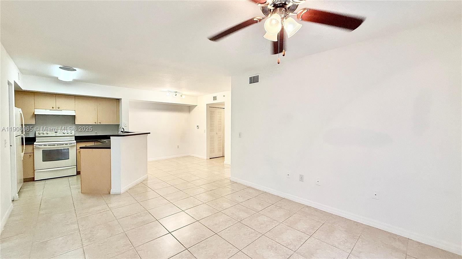 4211 San Marino Boulevard, Unit 205 West Palm Beach, FL 33409 - Photo 3 of 22 a kitchen with white cabinets and stainless steel appliances