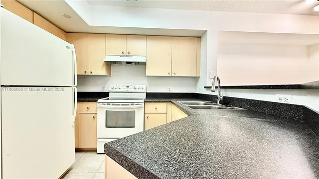 a kitchen with a sink a stove and a refrigerator