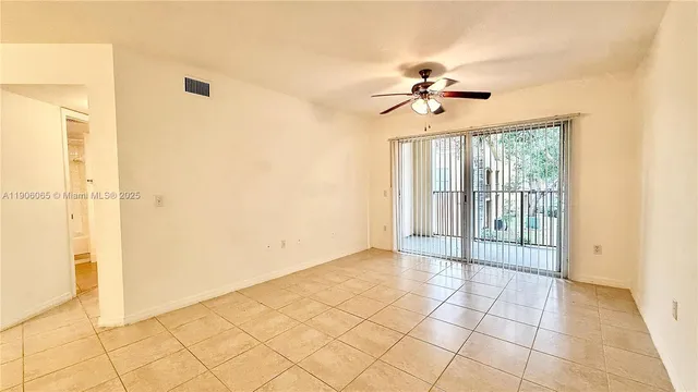 a view of a livingroom with a chandelier fan and windows