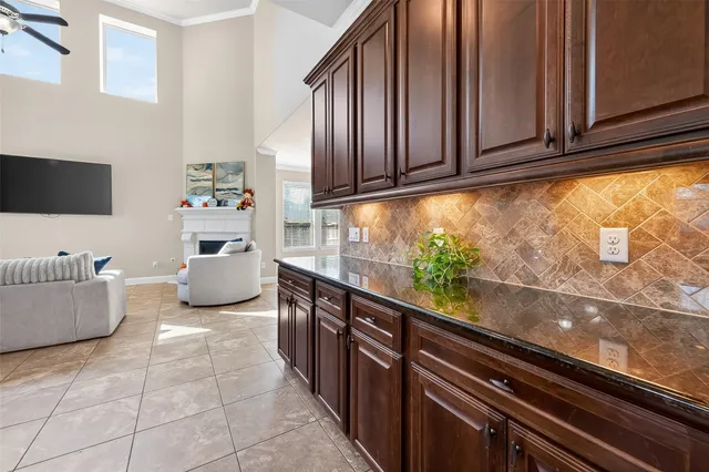 a kitchen with stainless steel appliances granite countertop a refrigerator a stove a sink a dining table and chairs with wooden floor