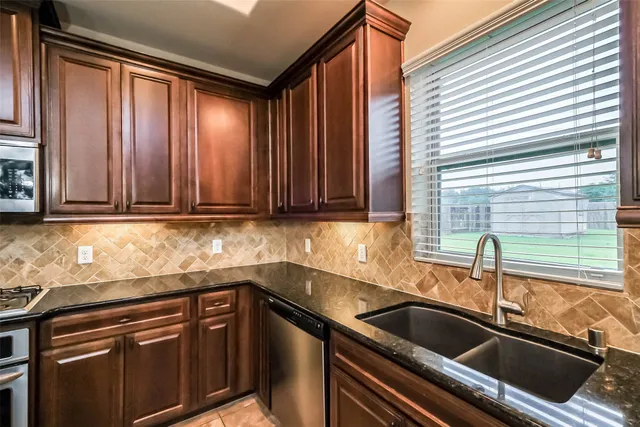 a kitchen with stainless steel appliances granite countertop a stove microwave and sink