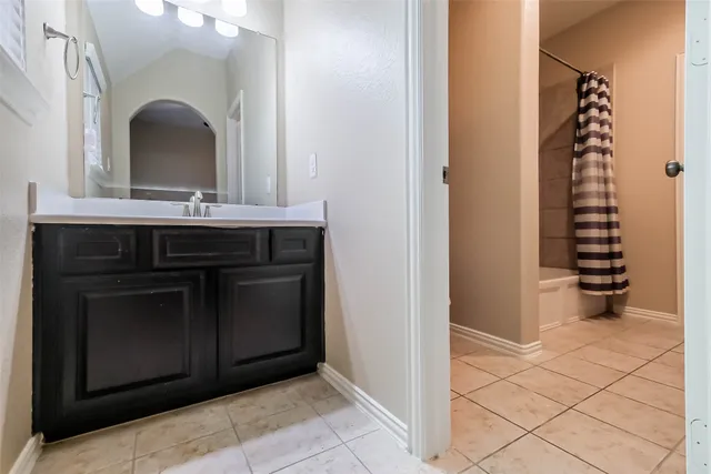 a bedroom with a bed tv and a window