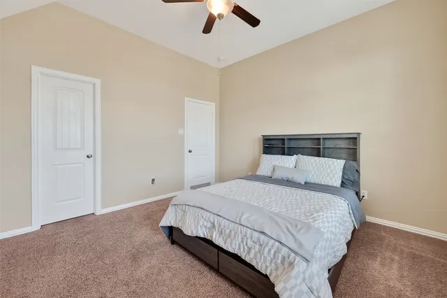 a spacious bedroom with a bed and a ceiling fan