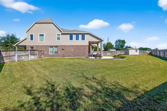 a view of a house with a big yard and large trees