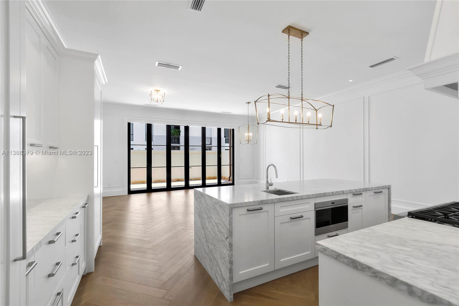 2607 Anderson Road Coral Gables, FL 33134 - Photo 30 of 96 a kitchen with kitchen island granite countertop a sink cabinets and stainless steel appliances