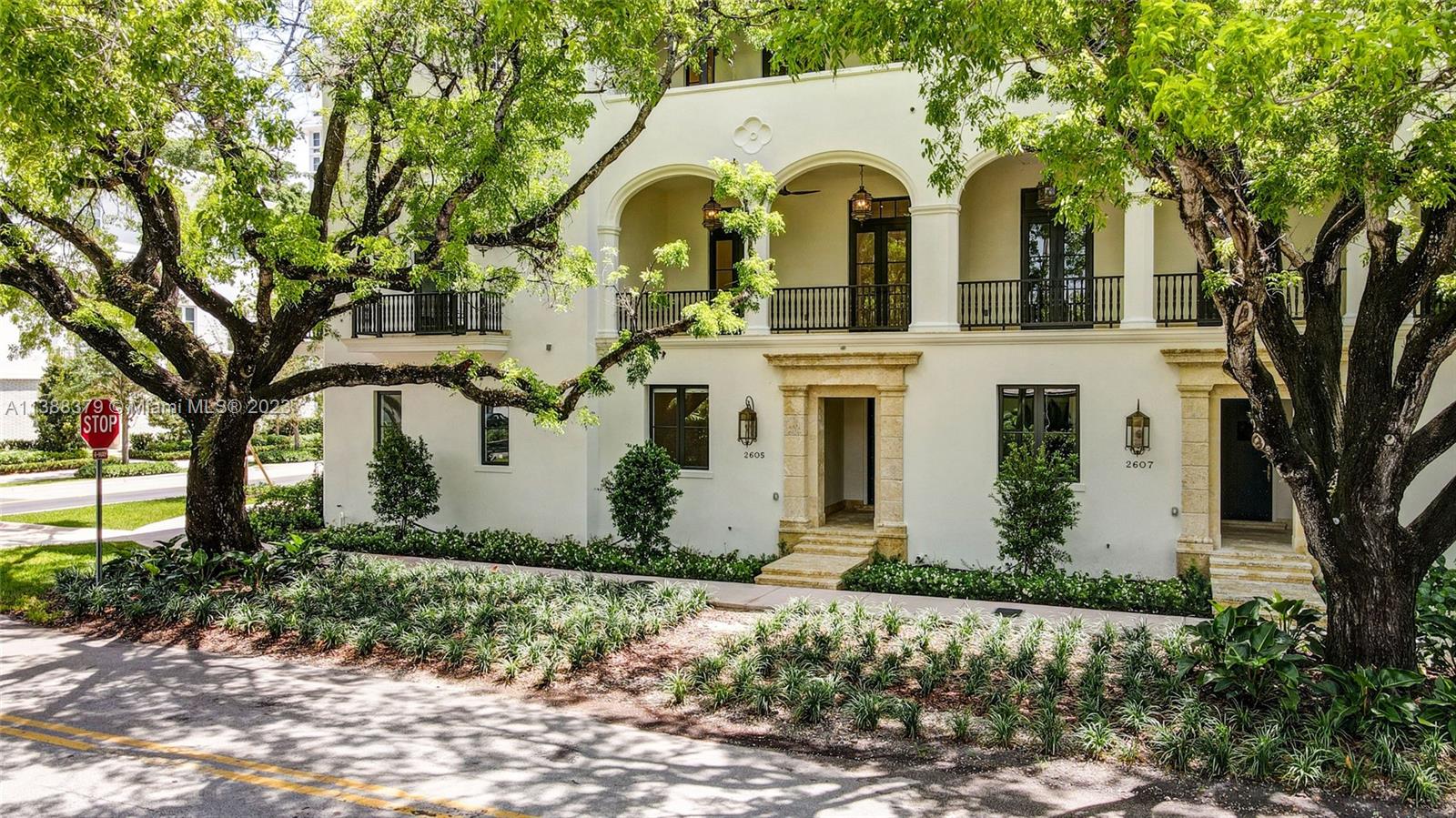 2607 Anderson Road Coral Gables, FL 33134 - Photo 4 of 96 a view of a white house with large windows and a lawn chairs