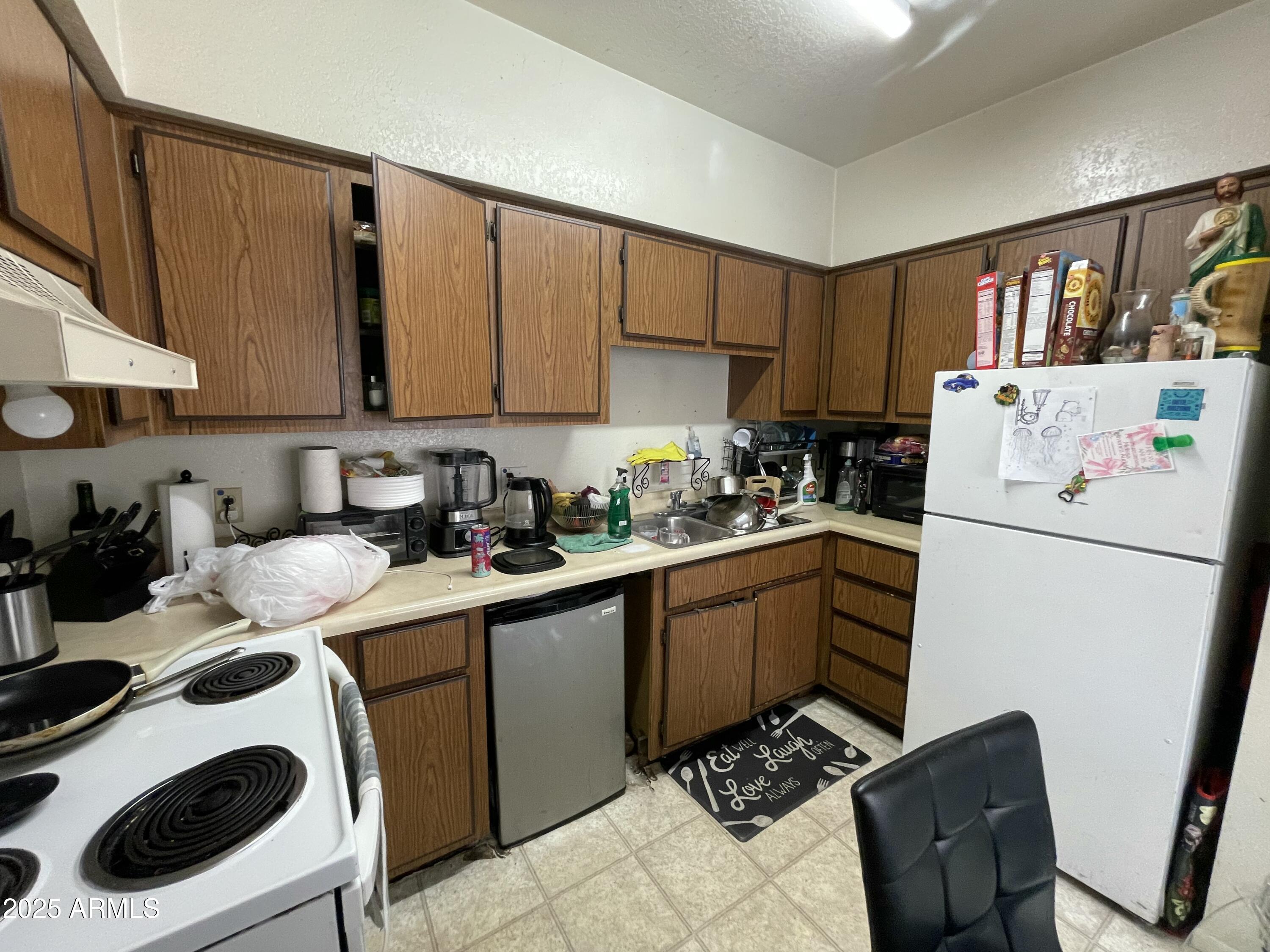 2822 East Kathleen Road Phoenix, AZ 85032 - Photo 26 of 30 a kitchen with a sink a refrigerator and cabinets
