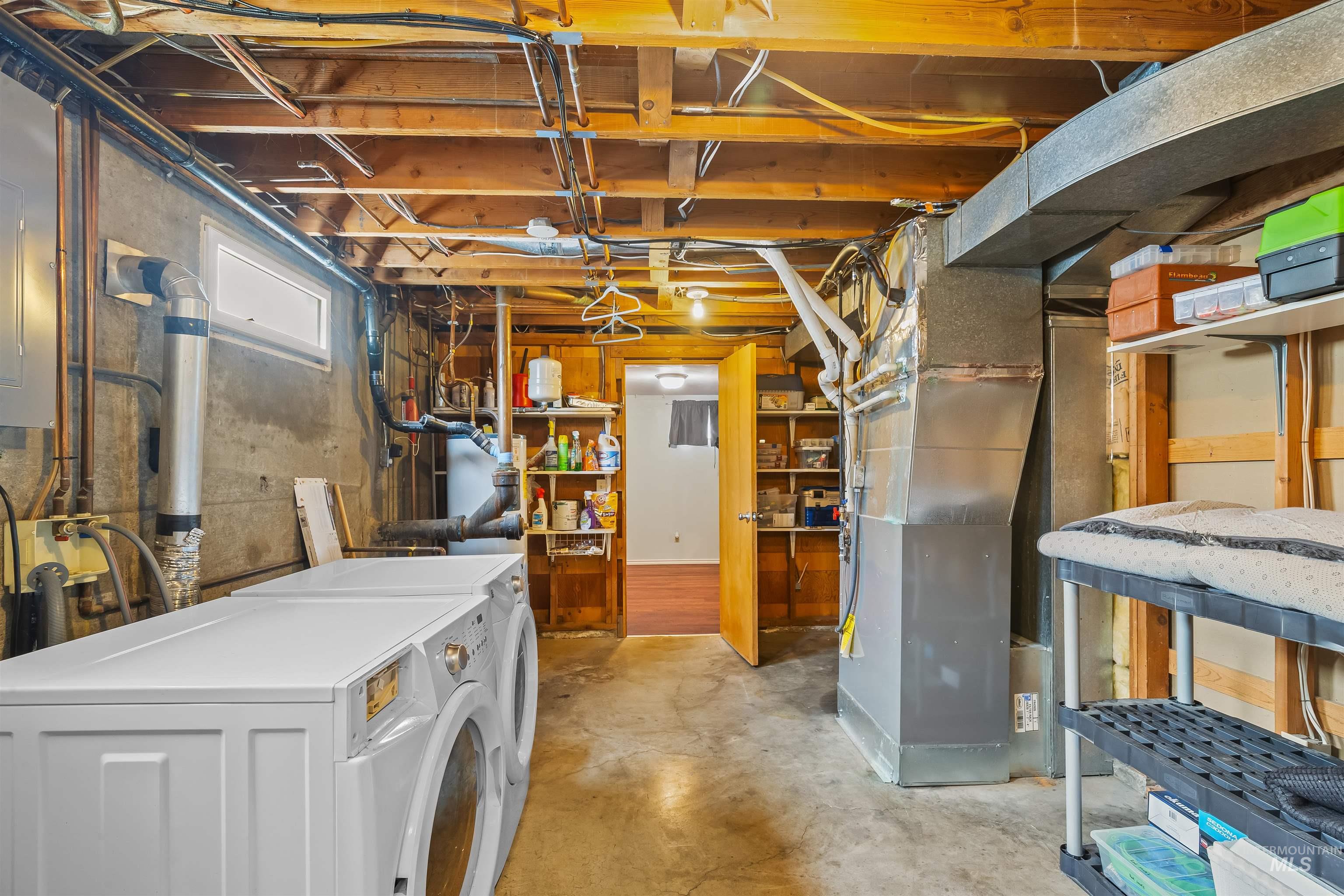 3620 18th Street Lewiston, ID 83501 - Photo 25 of 32 Utility area featuring exposed wood ceiling joists, concrete flooring, a wall-mounted water heater, and a small horizontal window
