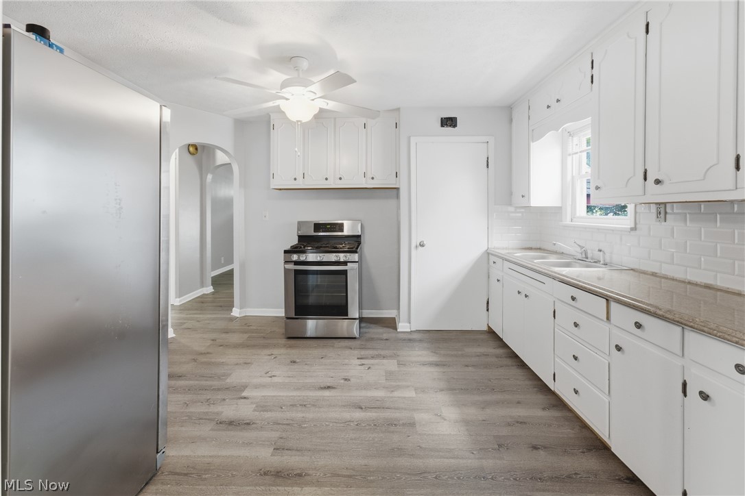 311 Fowles Road Berea, OH 44017 - Photo 8 of 40 Kitchen with wood-finish flooring, white cabinetry, and stainless steel appliances