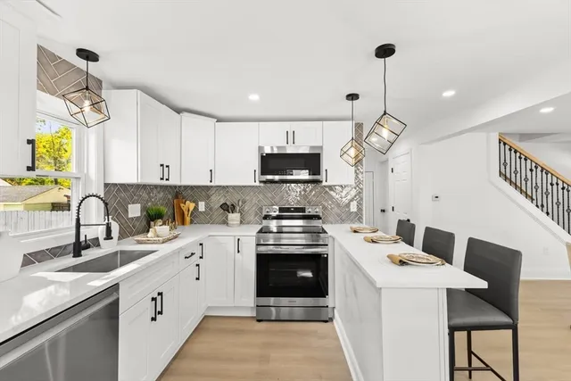 a kitchen with a sink stainless steel appliances and white cabinets