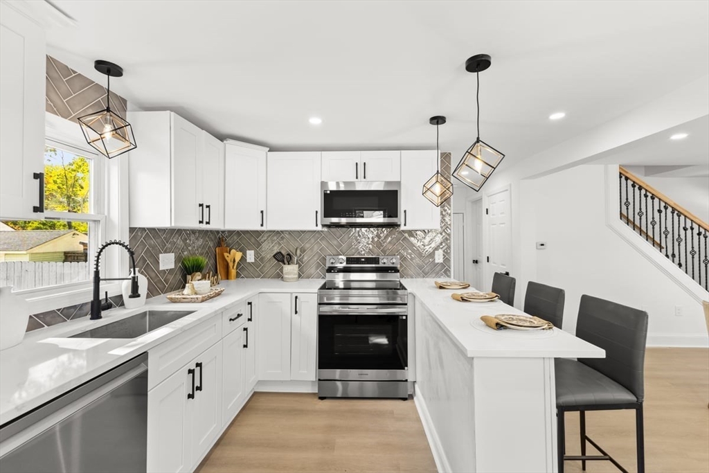a kitchen with a sink stainless steel appliances and white cabinets