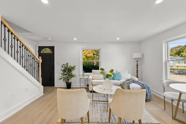 a living room with furniture and potted plants