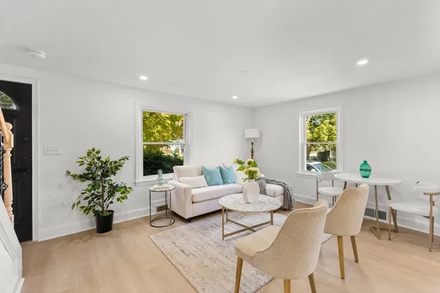 a living room with furniture plant and a window