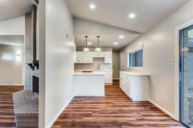 a view of a kitchen with kitchen island a sink stainless steel appliances and cabinets