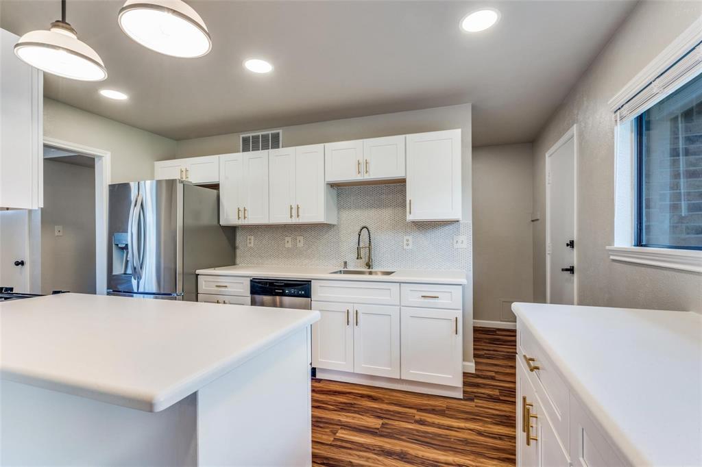 7904 Simpkins Place Plano, TX 75025 - Photo 12 of 24 a kitchen that has a lot of cabinets in it and wooden floors