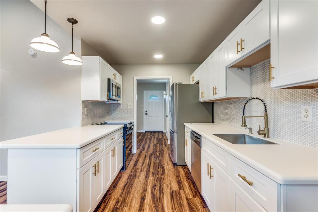 7904 Simpkins Place Plano, TX 75025 - Photo 13 of 24 a kitchen with kitchen island a sink stove and wooden floor