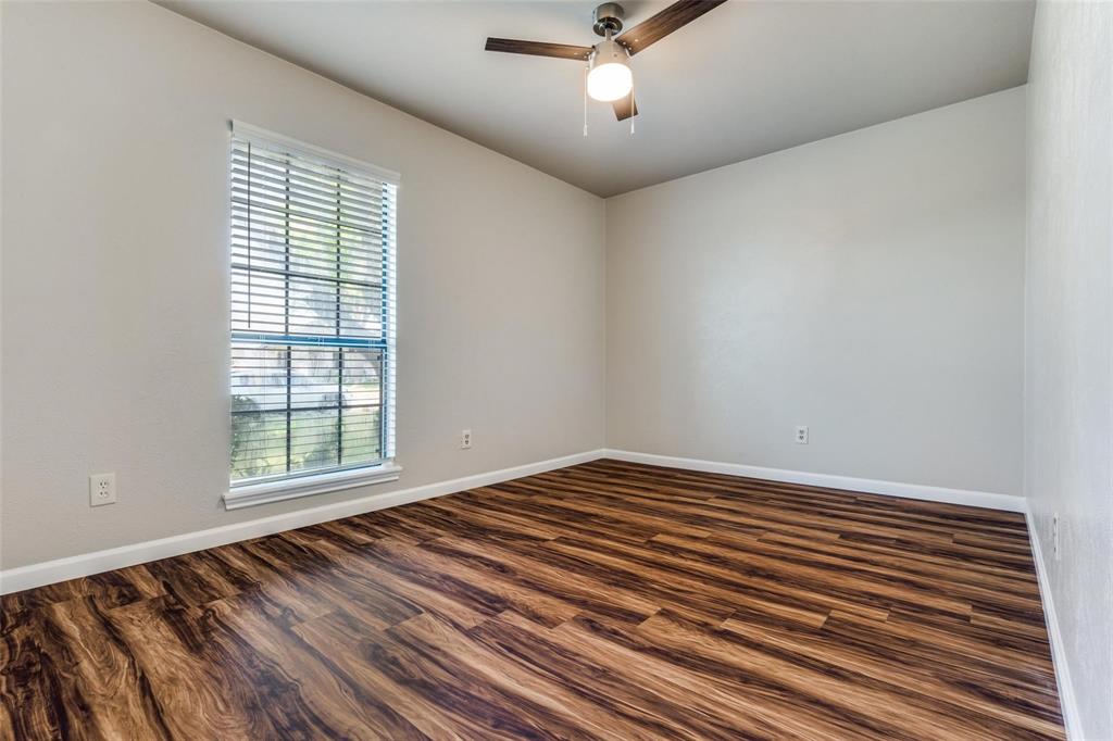 7904 Simpkins Place Plano, TX 75025 - Photo 20 of 24 a view of a room with a ceiling fan and wooden floor