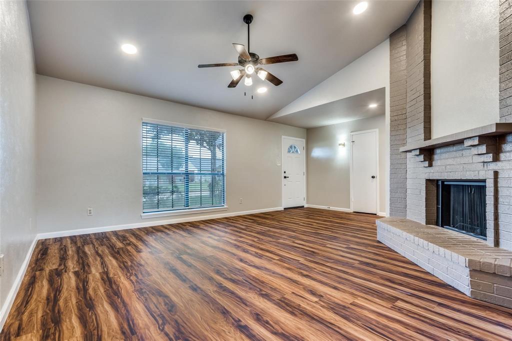 7904 Simpkins Place Plano, TX 75025 - Photo 3 of 24 a view of an empty room with wooden floor fireplace and a window