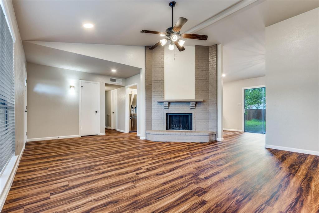 7904 Simpkins Place Plano, TX 75025 - Photo 6 of 24 a view of an empty room with wooden floor fireplace and a window