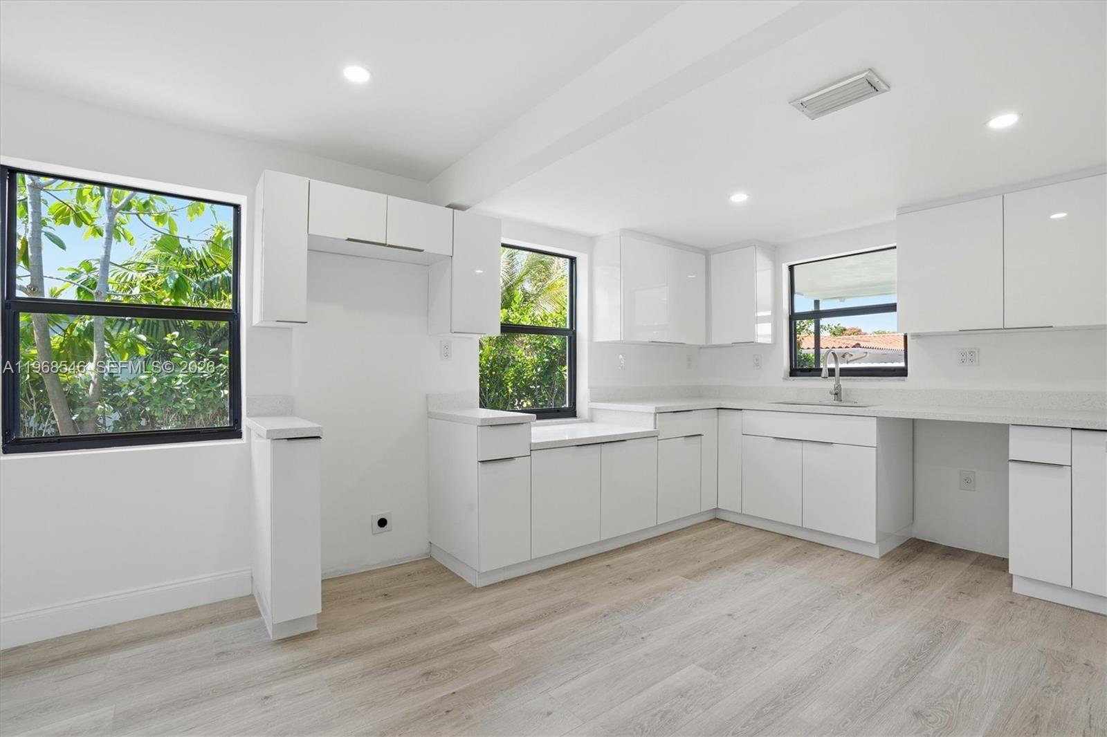 4237 Southwest 7th Street Miami, FL 33134 - Photo 9 of 31 a kitchen with white cabinets a window and appliances