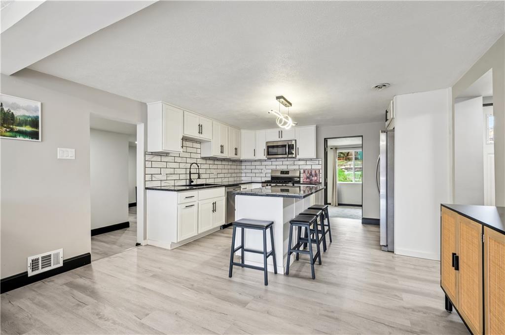 856 Cleveland Avenue Brackenridge, PA 15014 - Photo 11 of 35 a kitchen with white cabinets and stainless steel appliances
