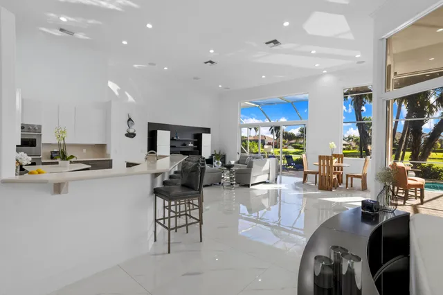 a living room with furniture a lamp and large window