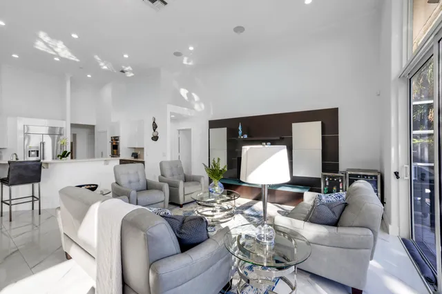 a kitchen with a refrigerator a sink and chairs