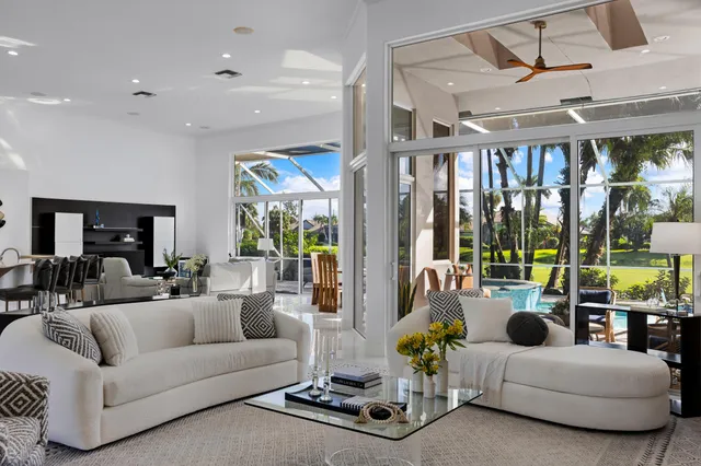 a living room with furniture ceiling fan and a large window